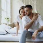 Casal sentado na cama representando distância emocional e sexo por obrigação