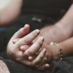 Duas pessoas de mãos dadas representando presença, conexão e mindfulness no sexo