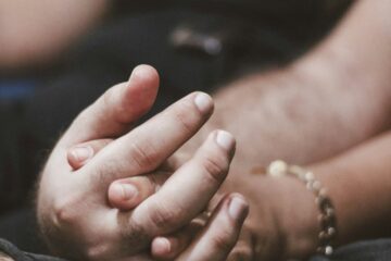 Duas pessoas de mãos dadas representando presença, conexão e mindfulness no sexo