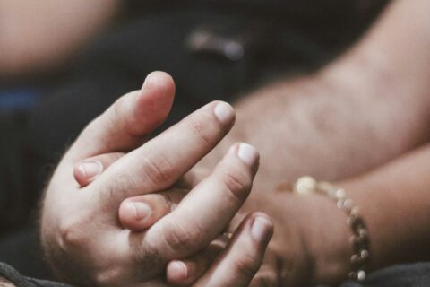 Duas pessoas de mãos dadas representando presença, conexão e mindfulness no sexo